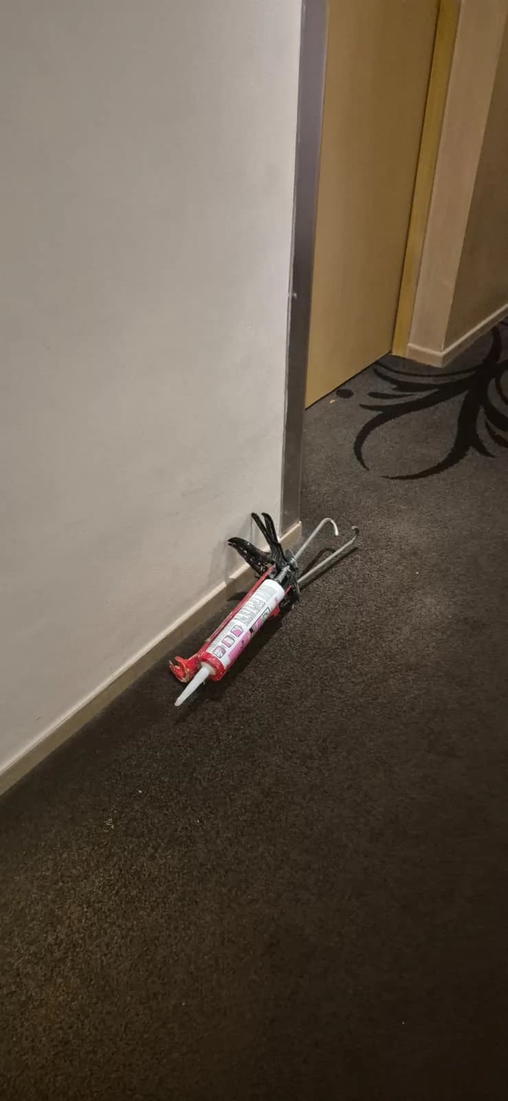 Construction tools and materials beside a hotel corridor wall